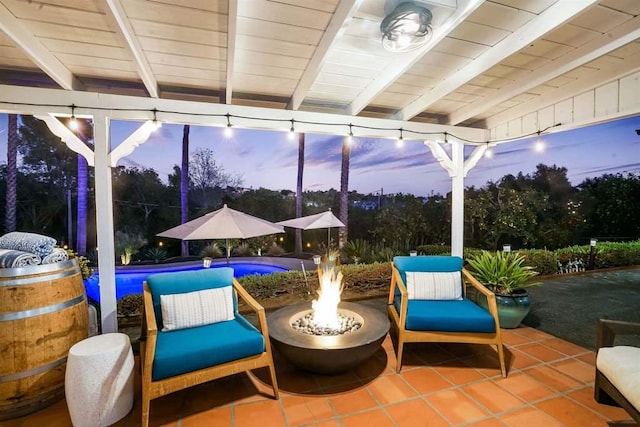 patio terrace at dusk featuring an outdoor fire pit