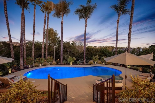 pool at dusk with a patio