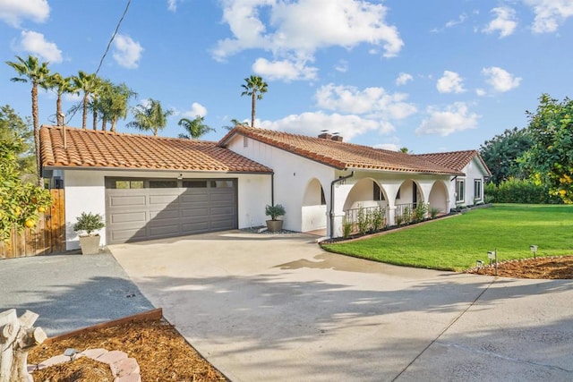 mediterranean / spanish-style house featuring a garage and a front lawn