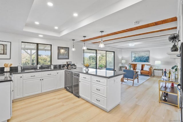 kitchen with decorative light fixtures, kitchen peninsula, light wood-type flooring, and white cabinetry