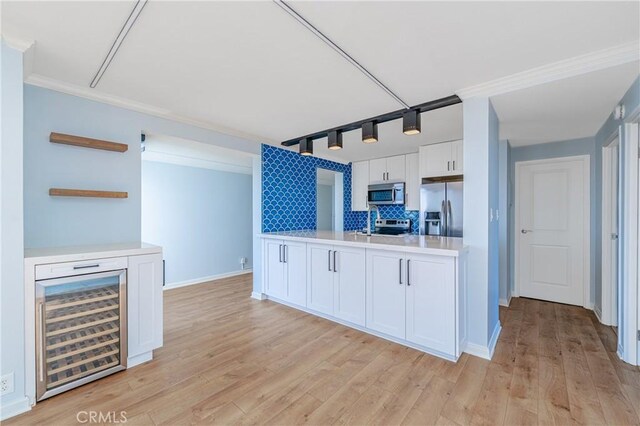 kitchen featuring beverage cooler, white cabinets, stainless steel appliances, light countertops, and open shelves