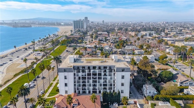 drone / aerial view with a water view, a view of the beach, and a city view