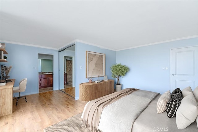 bedroom with ornamental molding, light wood-type flooring, ensuite bath, and baseboards