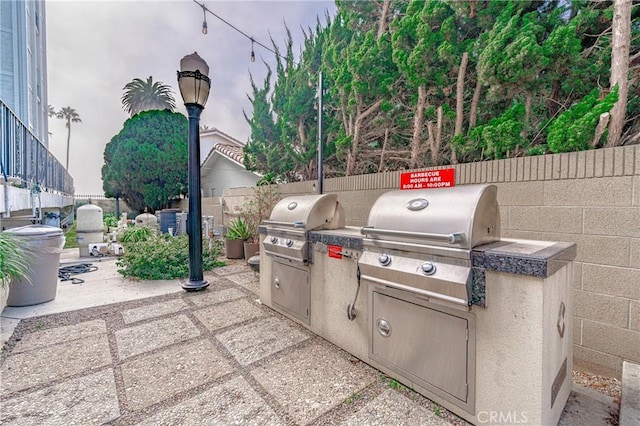 view of patio / terrace with a grill, area for grilling, and fence