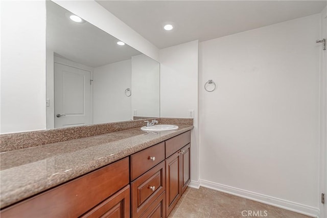 bathroom with recessed lighting, vanity, and baseboards