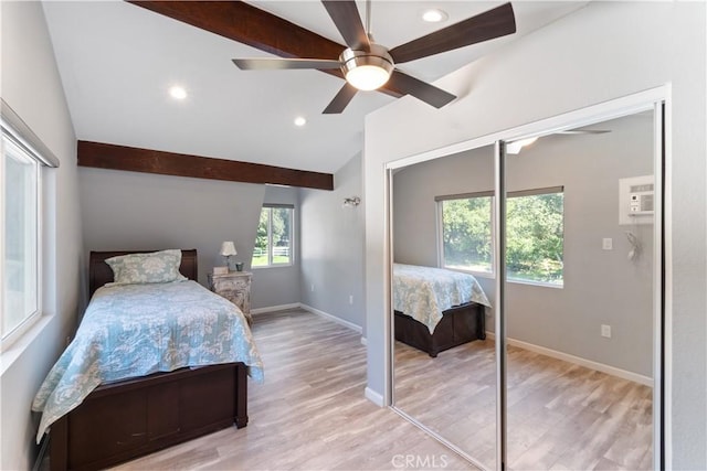 bedroom with ceiling fan, light wood-type flooring, a closet, and vaulted ceiling