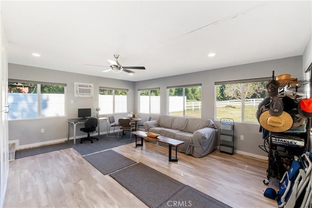 living room featuring ceiling fan, wood-type flooring, and a wall unit AC