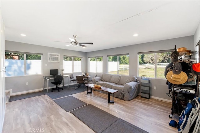 living room with a wall mounted AC, recessed lighting, wood finished floors, and baseboards