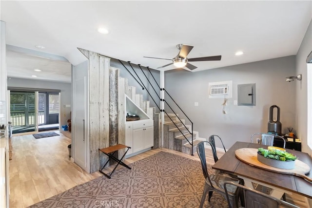 dining room featuring electric panel, a ceiling fan, stairs, light wood-style floors, and recessed lighting