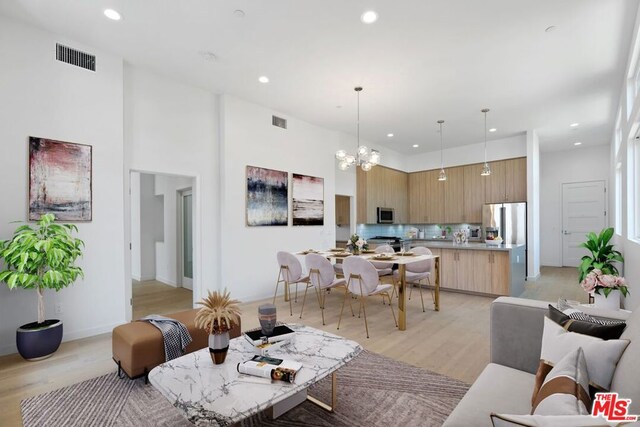 living room featuring an inviting chandelier and light hardwood / wood-style flooring