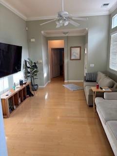 living room featuring light wood-type flooring and crown molding