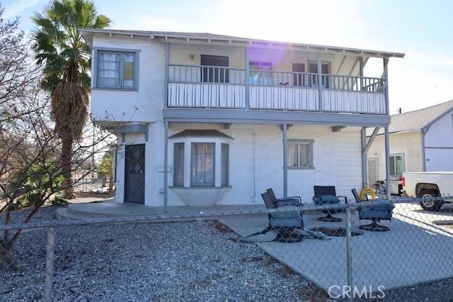 back of house featuring a patio area and a balcony