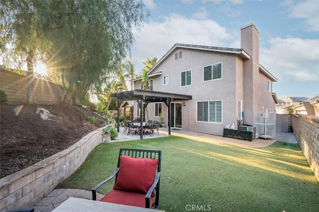 rear view of property featuring a yard, a pergola, and a patio area