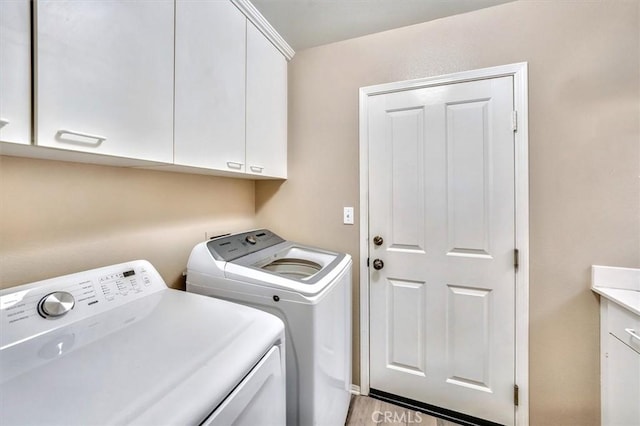 washroom with cabinets and washer and dryer