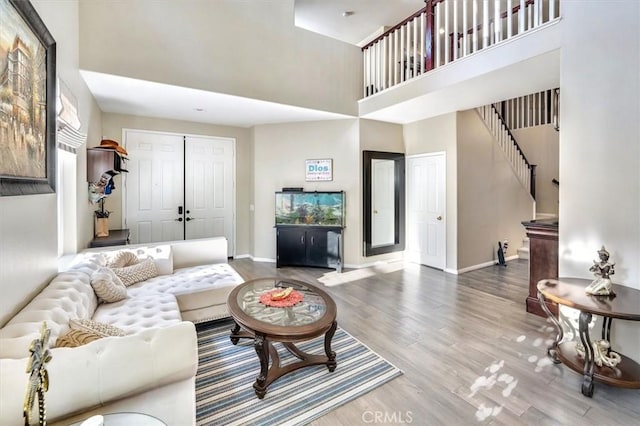 living room featuring hardwood / wood-style flooring and a towering ceiling