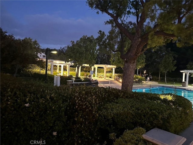 pool at dusk with a pergola