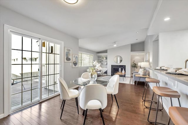 dining area with dark hardwood / wood-style flooring and vaulted ceiling