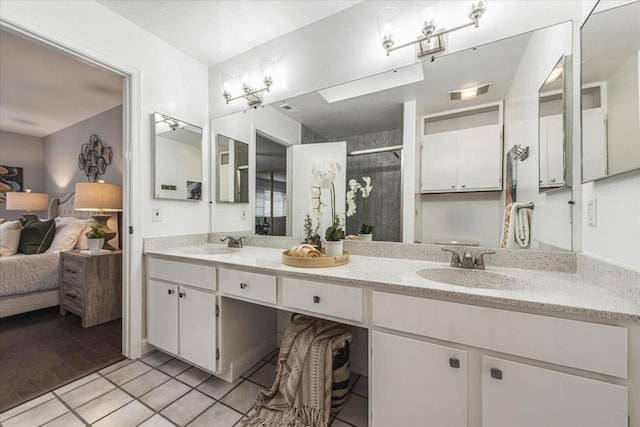 bathroom with a shower with door, tile patterned floors, and vanity