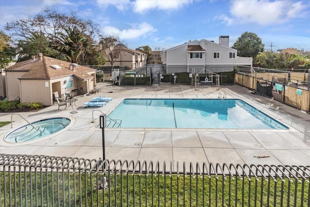 view of pool with a hot tub and a patio