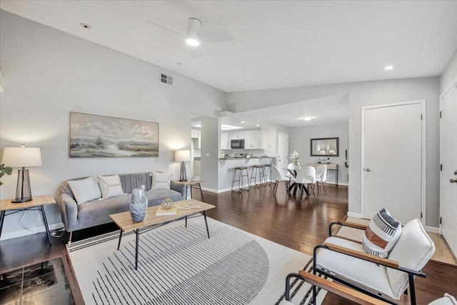 living room featuring ceiling fan, lofted ceiling, and wood-type flooring