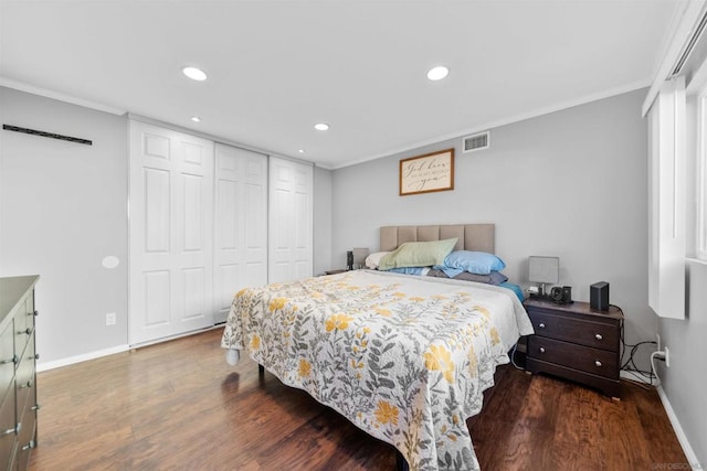 bedroom with a closet, dark hardwood / wood-style flooring, and ornamental molding