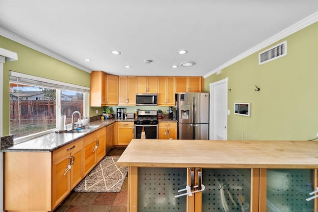 kitchen featuring appliances with stainless steel finishes, crown molding, butcher block counters, and sink