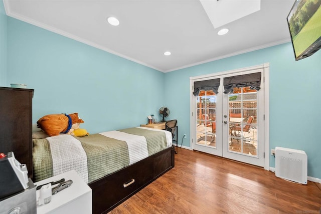 bedroom featuring access to outside, a skylight, ornamental molding, and hardwood / wood-style floors