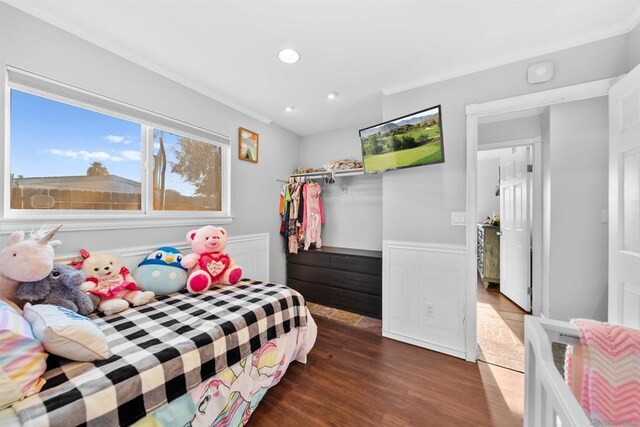 bedroom with dark hardwood / wood-style flooring and ornamental molding