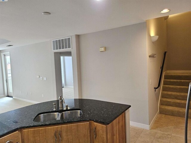 kitchen featuring dark stone counters and sink