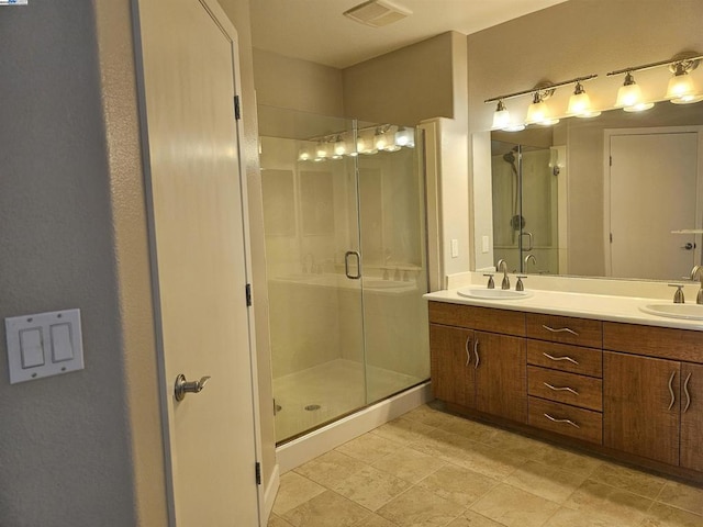 bathroom with a shower with shower door and vanity