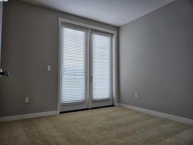 spare room featuring light colored carpet