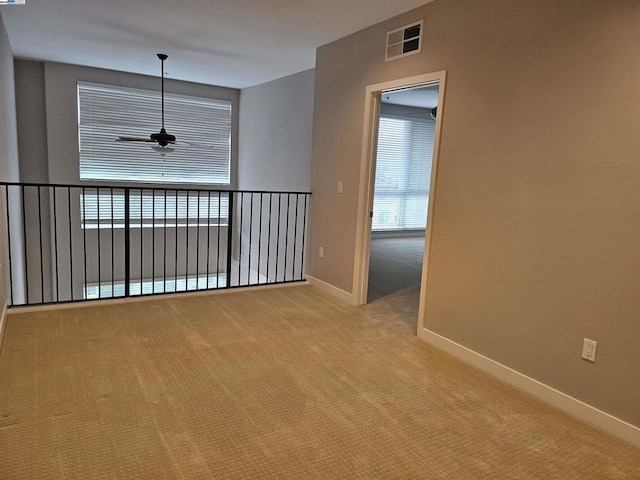 carpeted empty room featuring ceiling fan