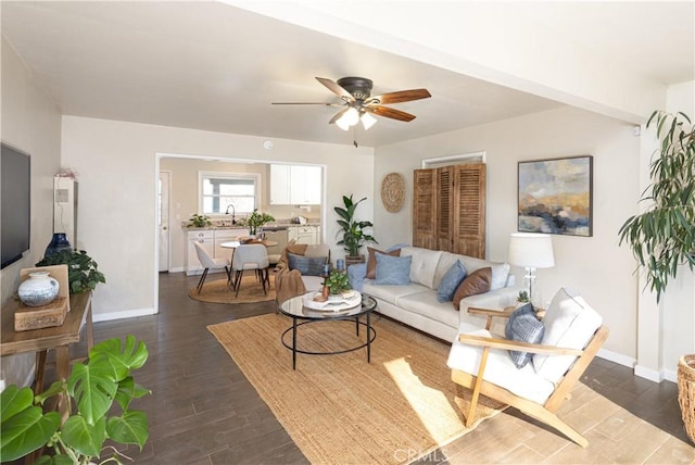 living room featuring dark wood-type flooring, sink, and ceiling fan