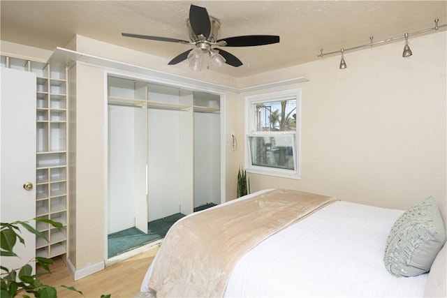 bedroom with ceiling fan, hardwood / wood-style flooring, and a closet