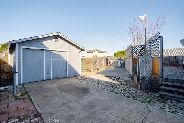 view of patio / terrace featuring a garage, an outbuilding, and a wooden deck