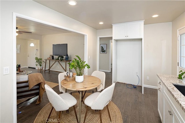 dining space with ceiling fan, dark hardwood / wood-style floors, and sink