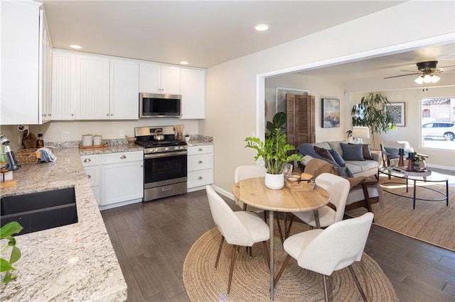 kitchen featuring dark wood-type flooring, appliances with stainless steel finishes, white cabinetry, and sink