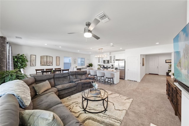 living room with light colored carpet and ceiling fan