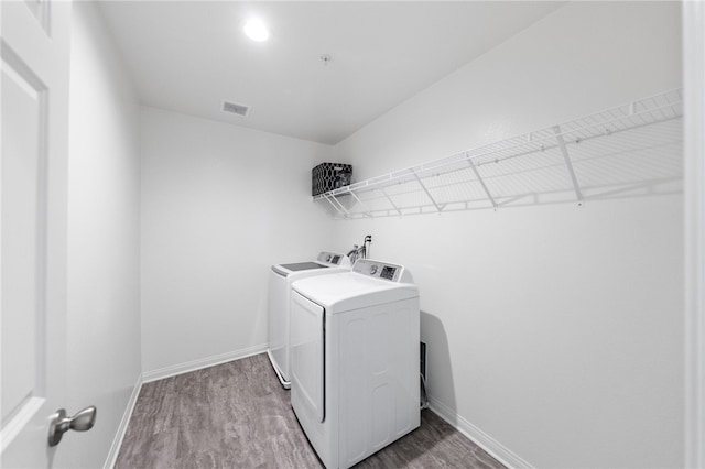 washroom featuring washer and dryer and wood-type flooring