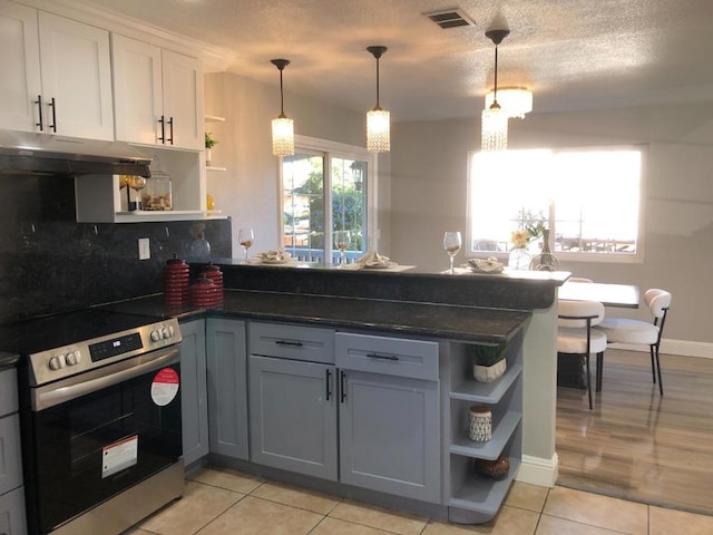 kitchen featuring kitchen peninsula, hanging light fixtures, white cabinets, and electric range