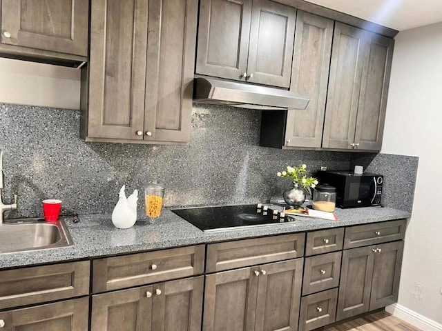 kitchen with black appliances, decorative backsplash, and dark brown cabinetry