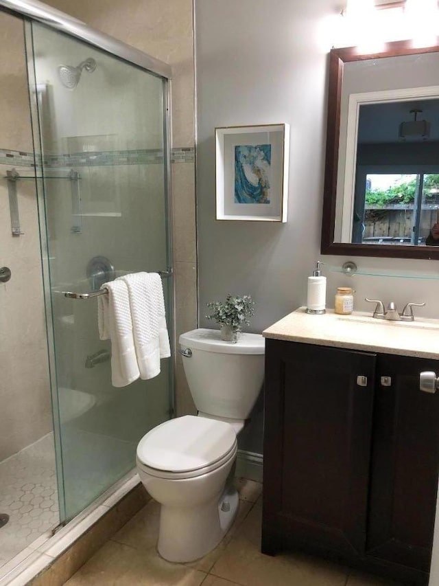 bathroom with toilet, tile patterned floors, an enclosed shower, and vanity