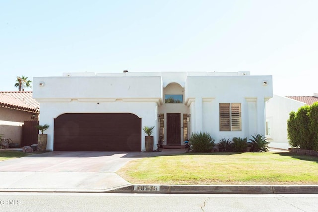 view of front of property with a garage and a front lawn