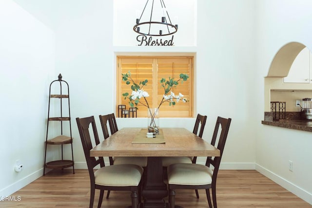 dining space with a chandelier and light hardwood / wood-style floors