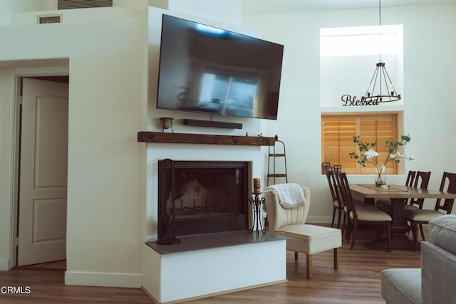 living room with hardwood / wood-style flooring and a notable chandelier