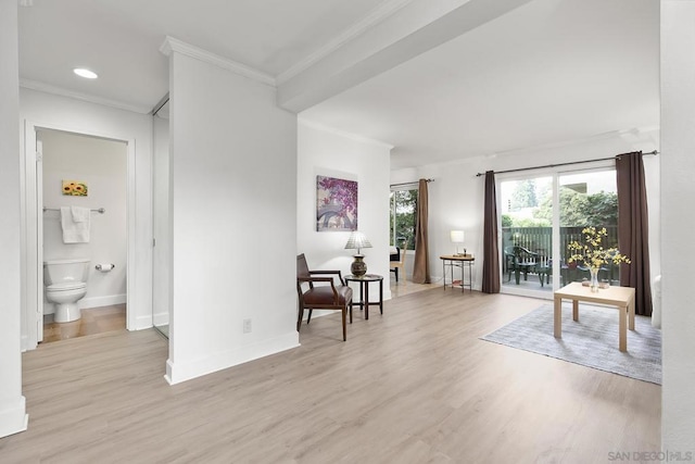 living area with ornamental molding and light hardwood / wood-style flooring