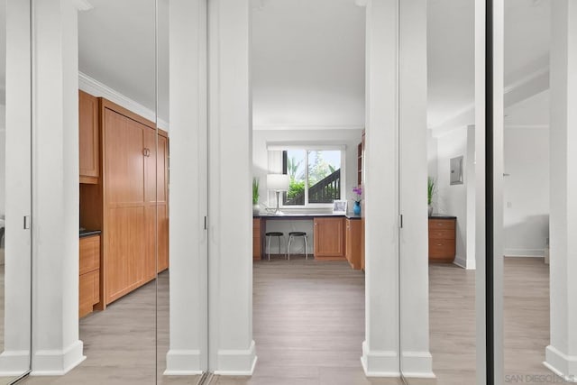 hall with light hardwood / wood-style flooring and ornamental molding