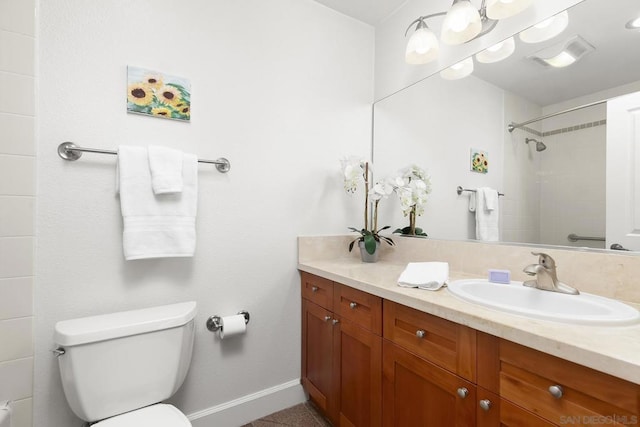 bathroom with vanity, toilet, and a tile shower