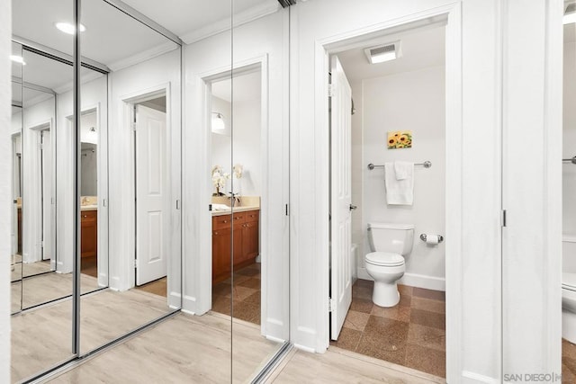 bathroom featuring vanity, ornamental molding, and toilet