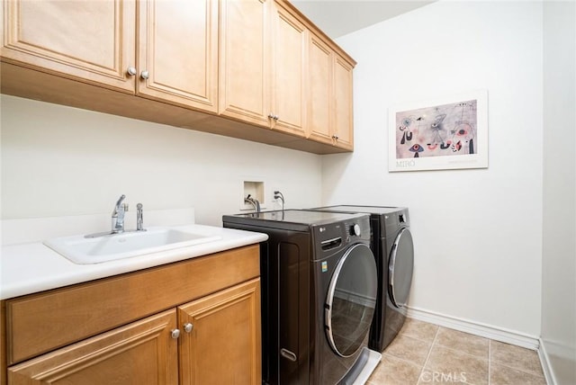 clothes washing area with washer and dryer, cabinets, light tile patterned floors, and sink